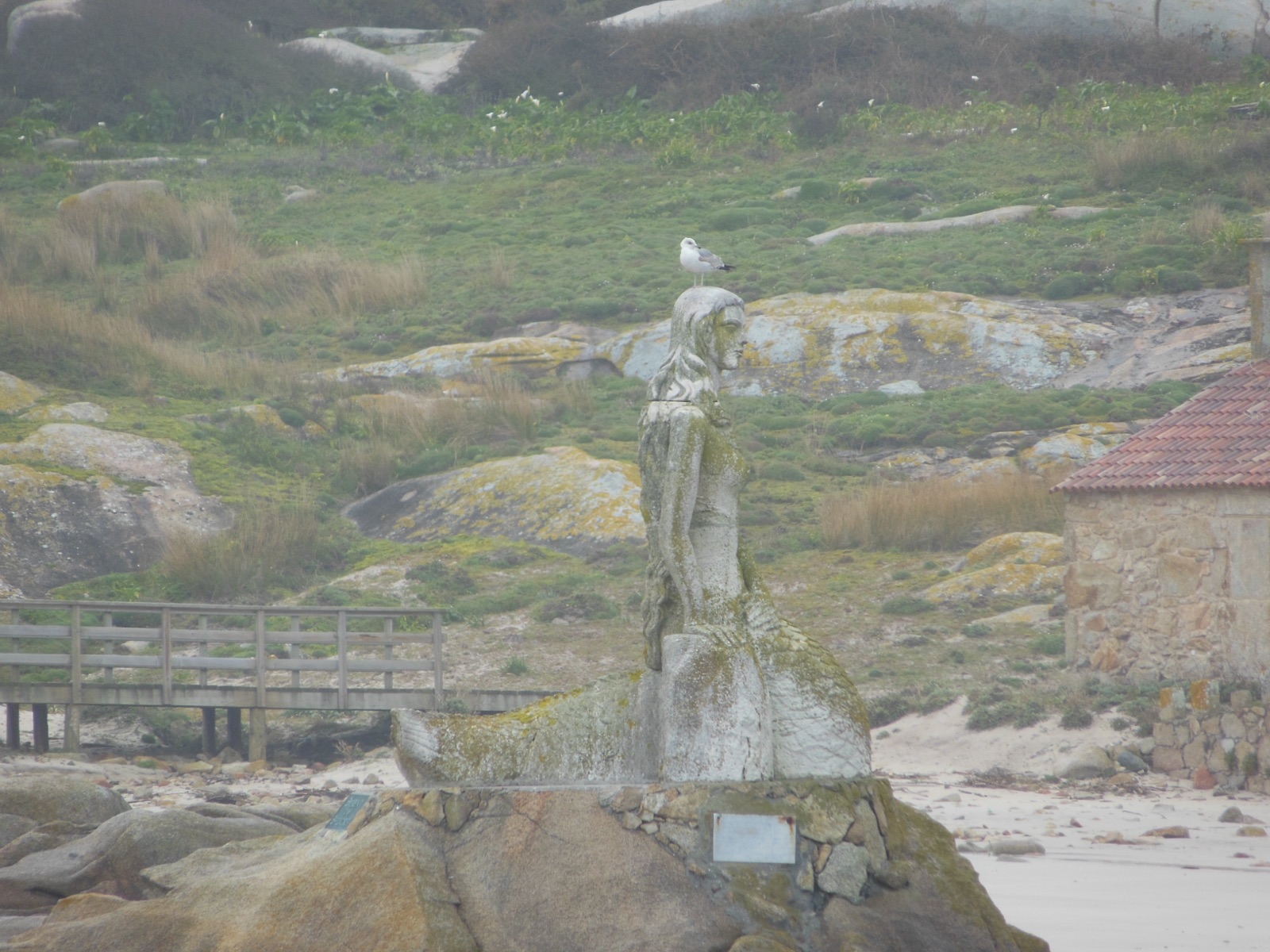 Escultura de la sirena Mariña sobre una roca en la Illa de Sálvora