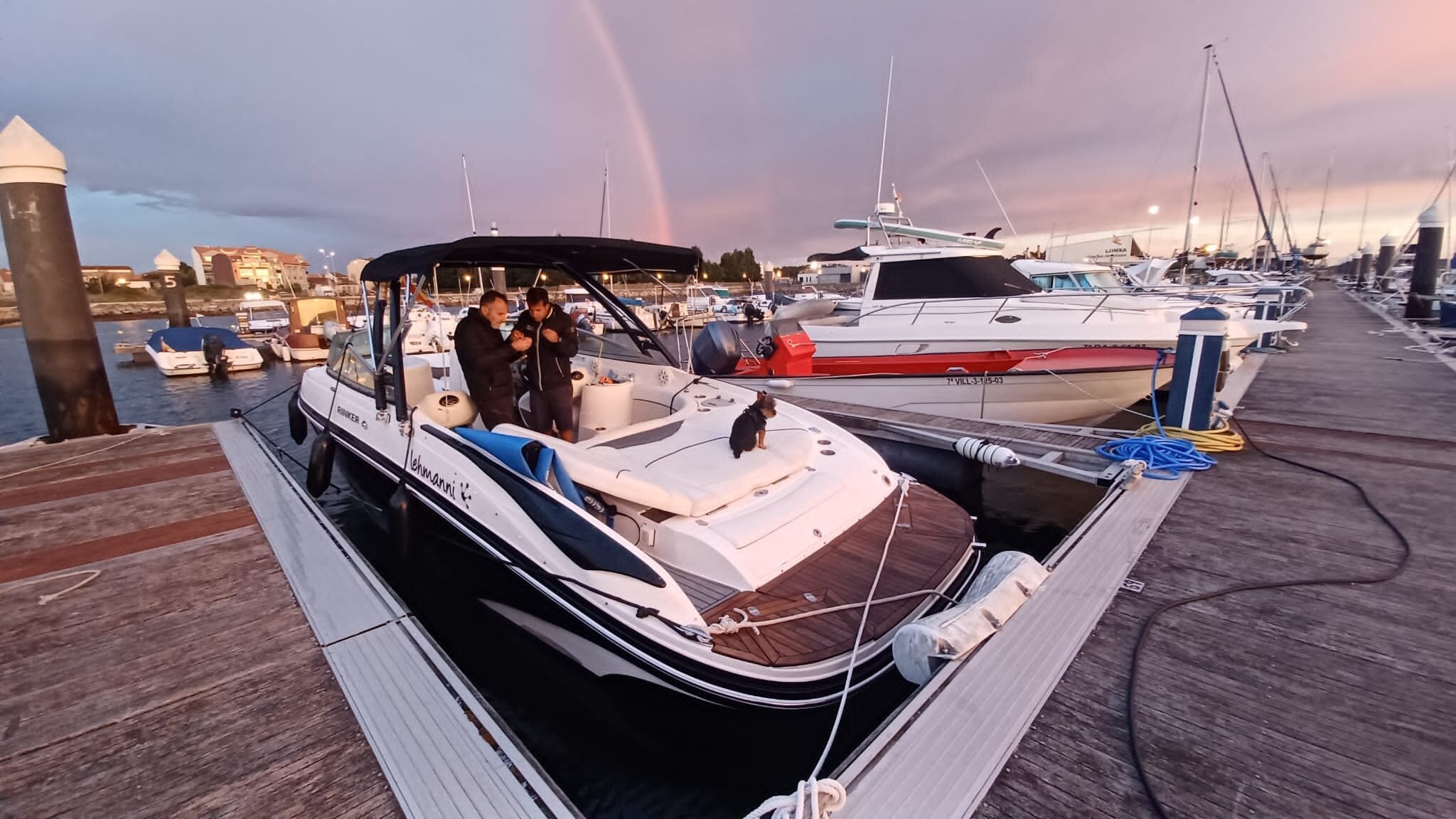 Atardecer dorado sobre la marina de Vilanova de Arousa con arcoíris y barcos amarrados