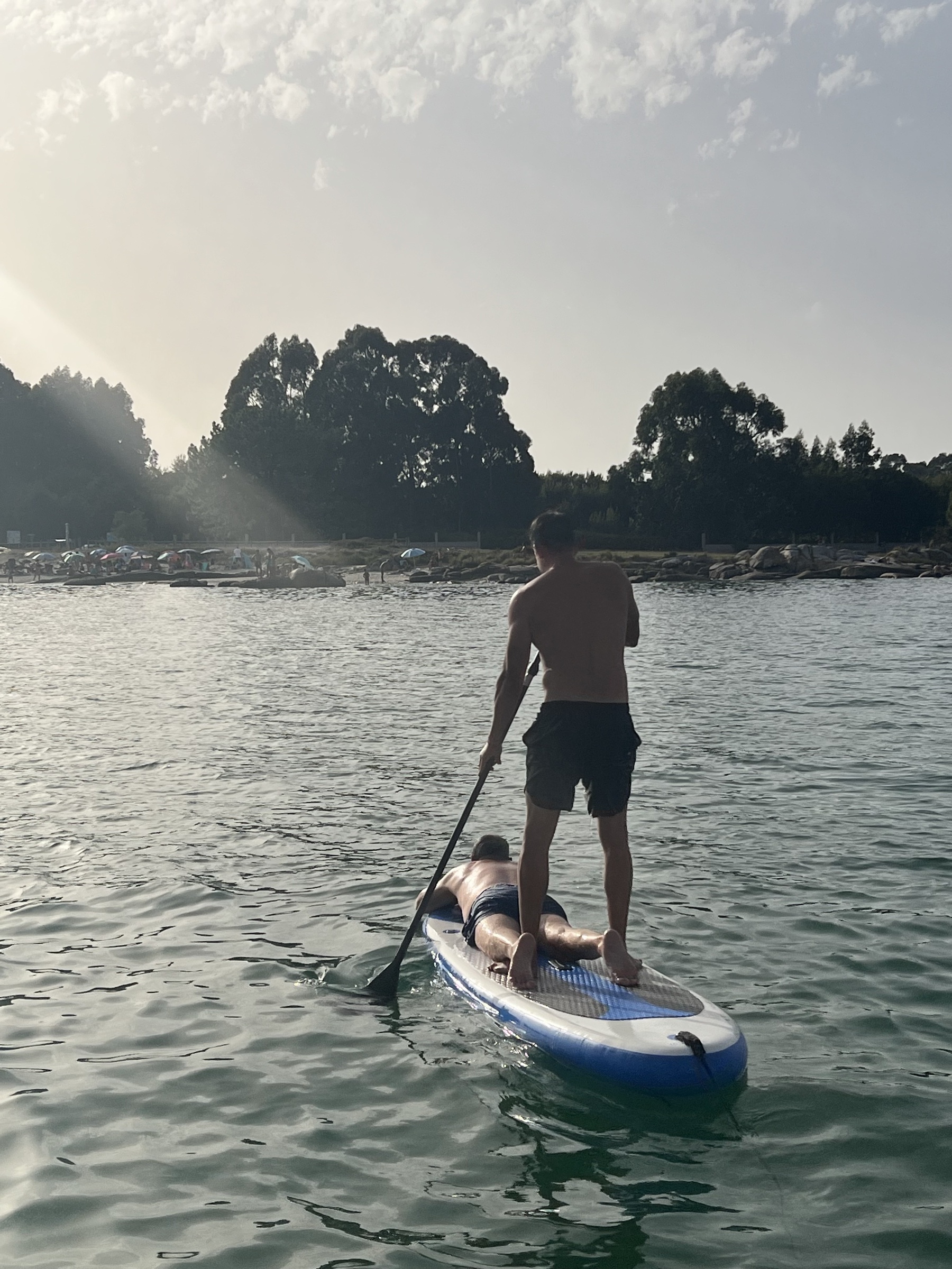 Sesión de paddle surf en aguas planas y calmas de una cala de la Ría de Arousa al atardecer